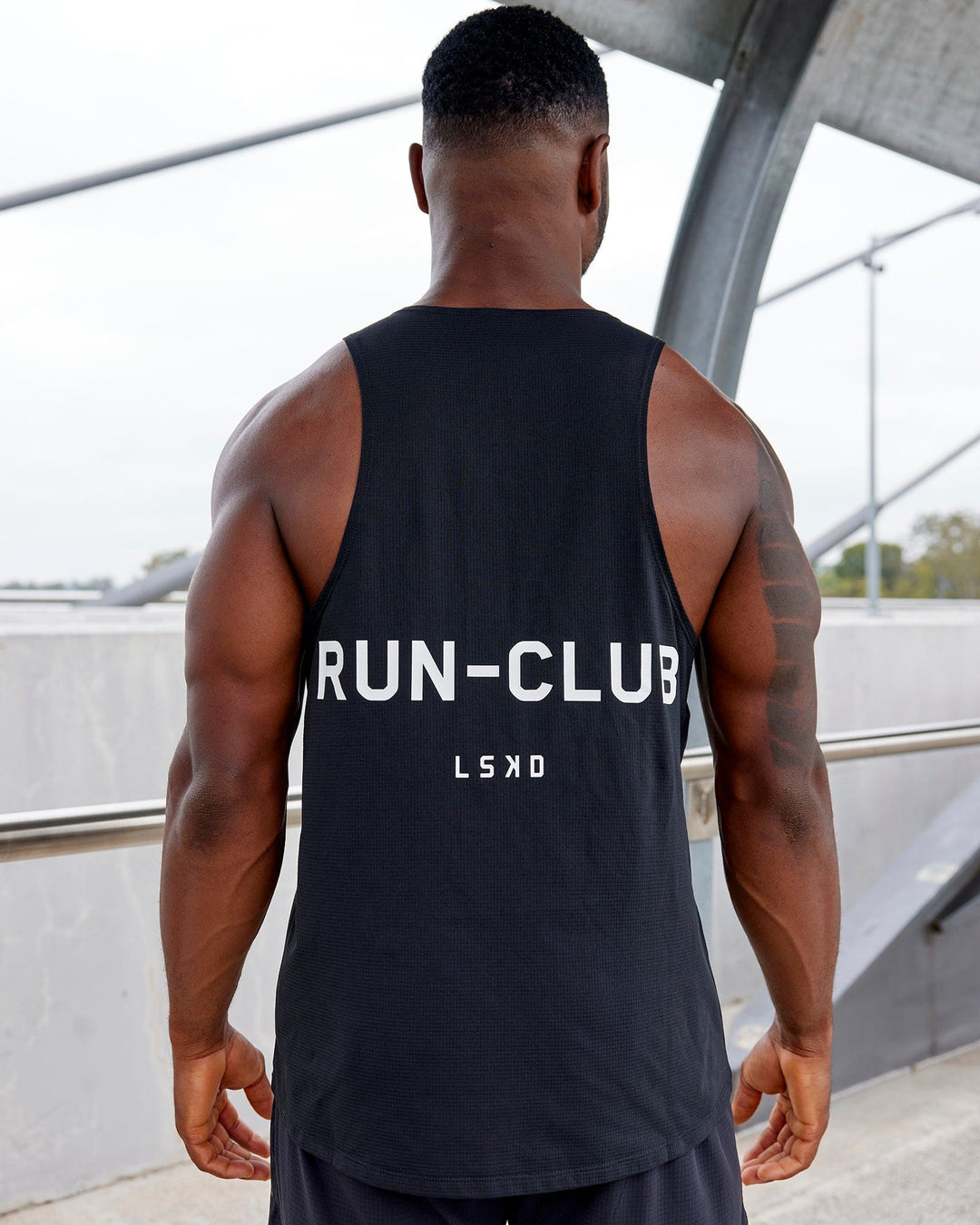 Man wearing RUN–CLUB Performance Tank - Black