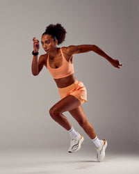 Woman wearing Rapid Sports Bra - Cantaloupe