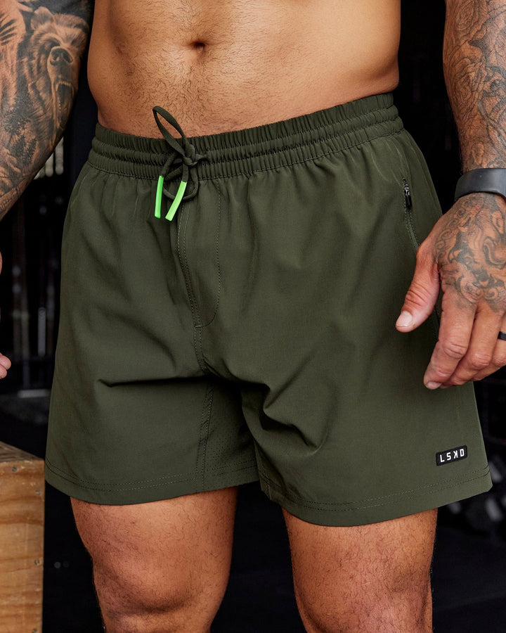 Man wearing Rep 5'' Performance Short - Forest Night-Lime