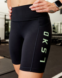 Woman wearing Rep Ultra High-Rise 9" Short Pockets - Black-Surreal Green | Model:Amber | Size:S