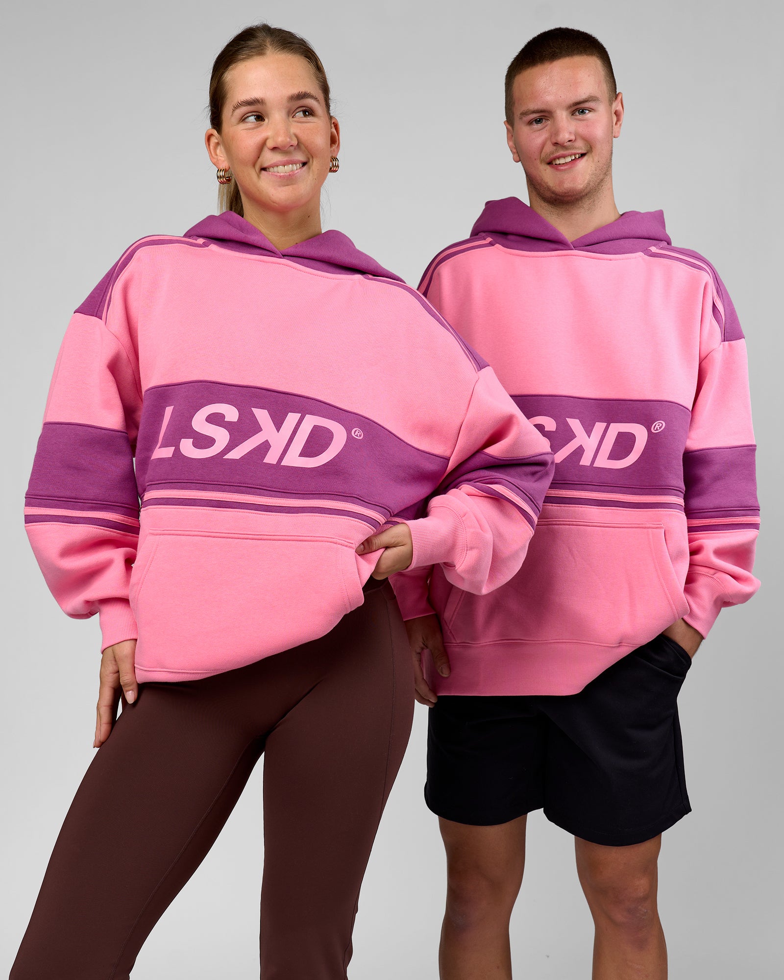 Duo wearing A-Team Oversized Hoodie - Candy Pink-Boysenberry | Model:Amity | Size:S | Model:Arran | Size:M