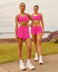 Woman wearing Velocity Sports Bra - Ultra Pink | Model:Duo| Size:Both