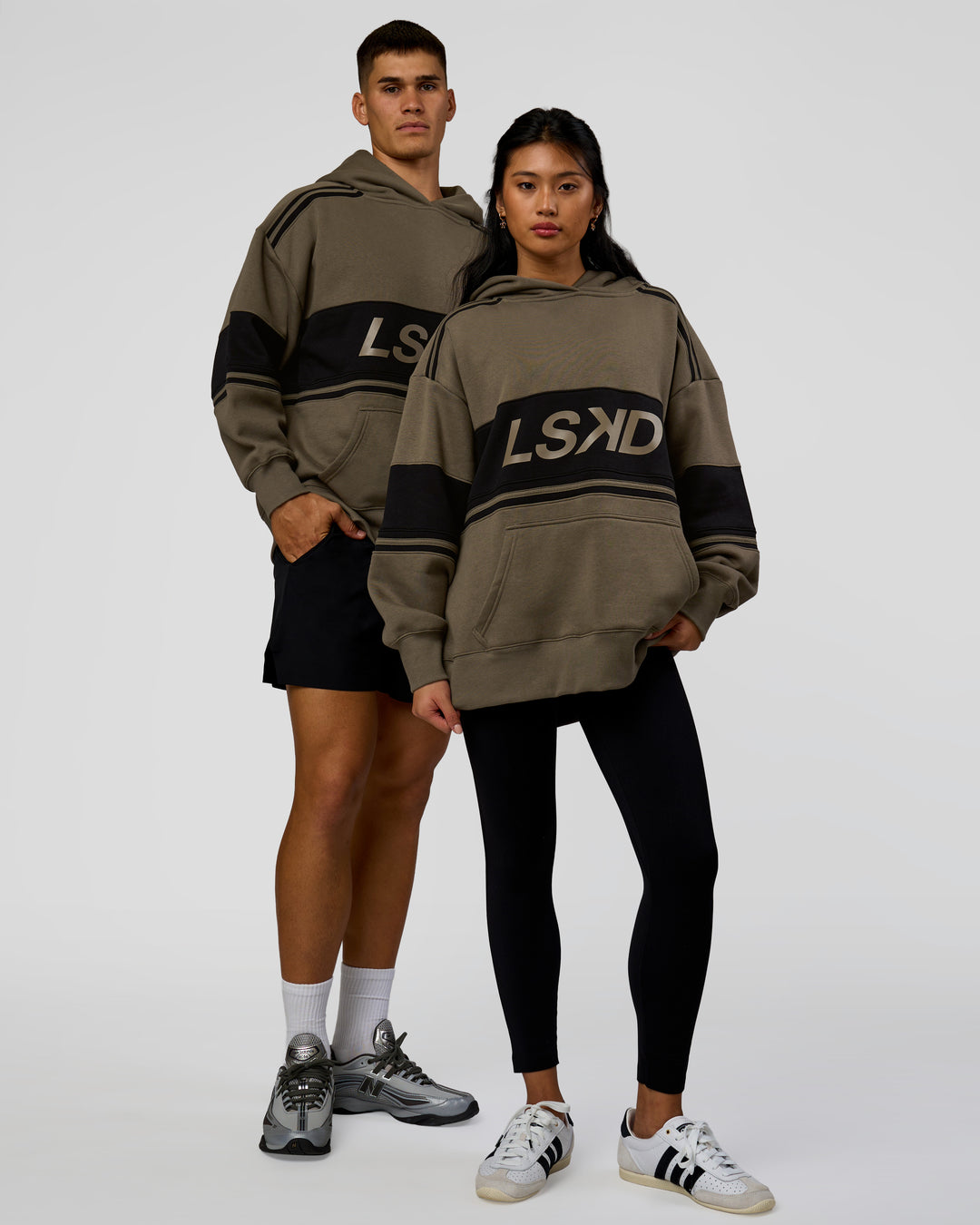 Duo wearing A-Team Oversized Hoodie - Walnut Grey-Caviar | Model:Jackson | Size:L | Model:Loren | Size:XS
