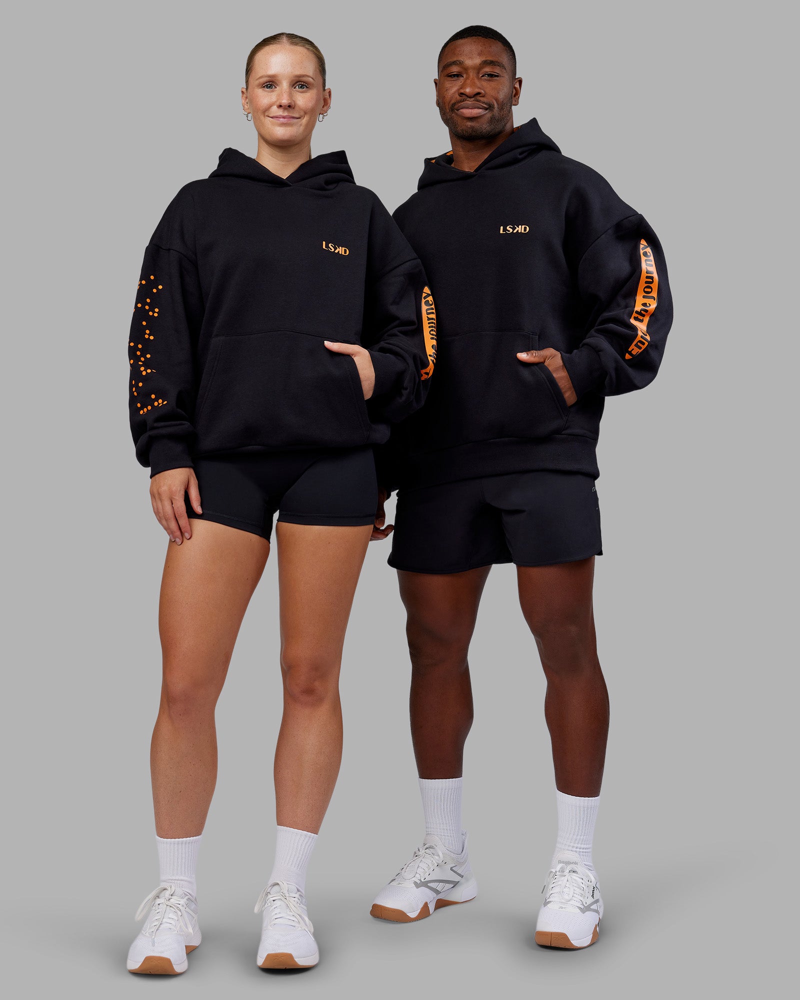 Duo wearing Hyped Unisex Oversized Hoodie - Black-Vibrant Orange | Model:Both | Size:Duo