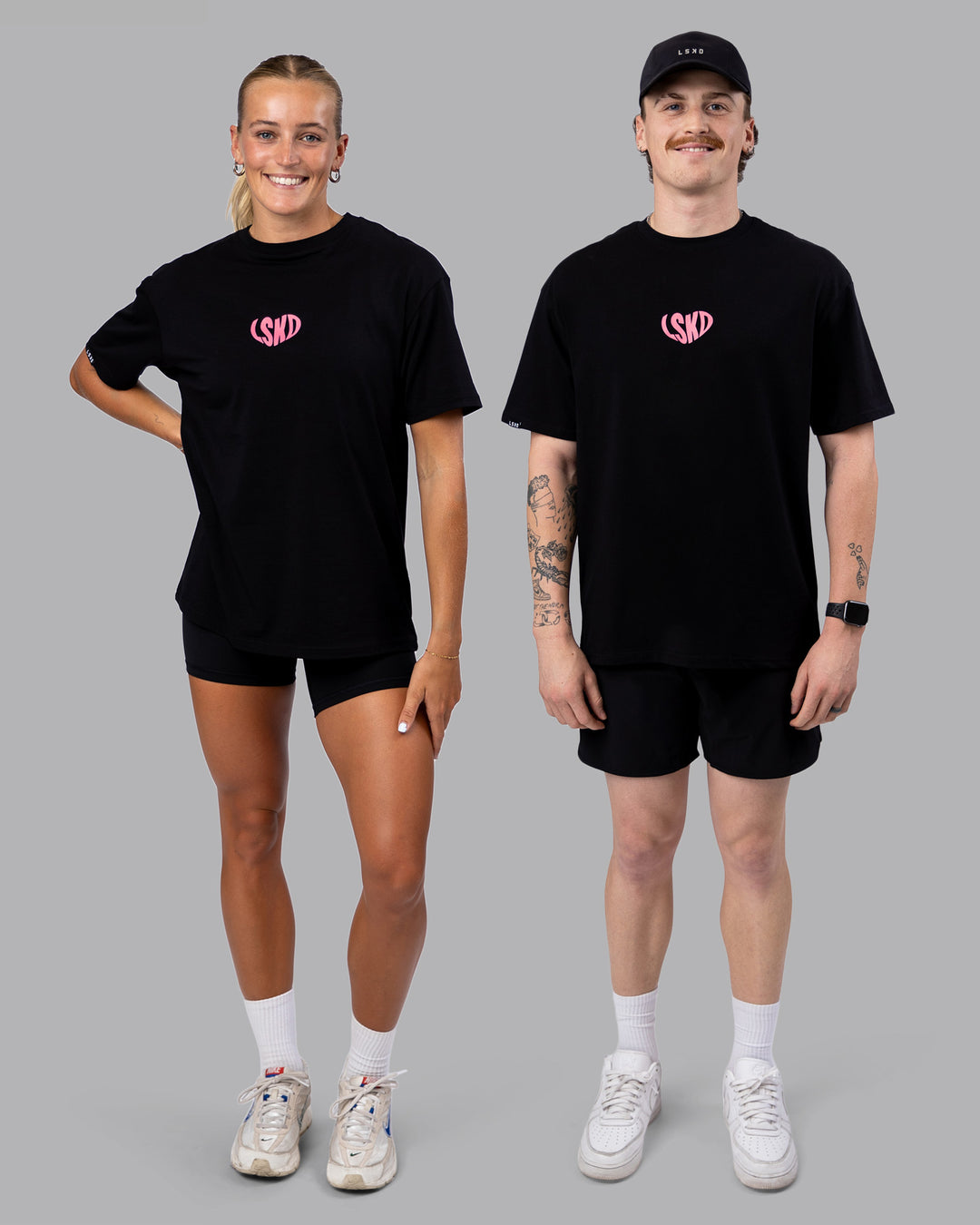 Duo wearing Unisex Love To Train FLXCotton Tee Oversize in Black-Pink Lemonade | Size:Duo
