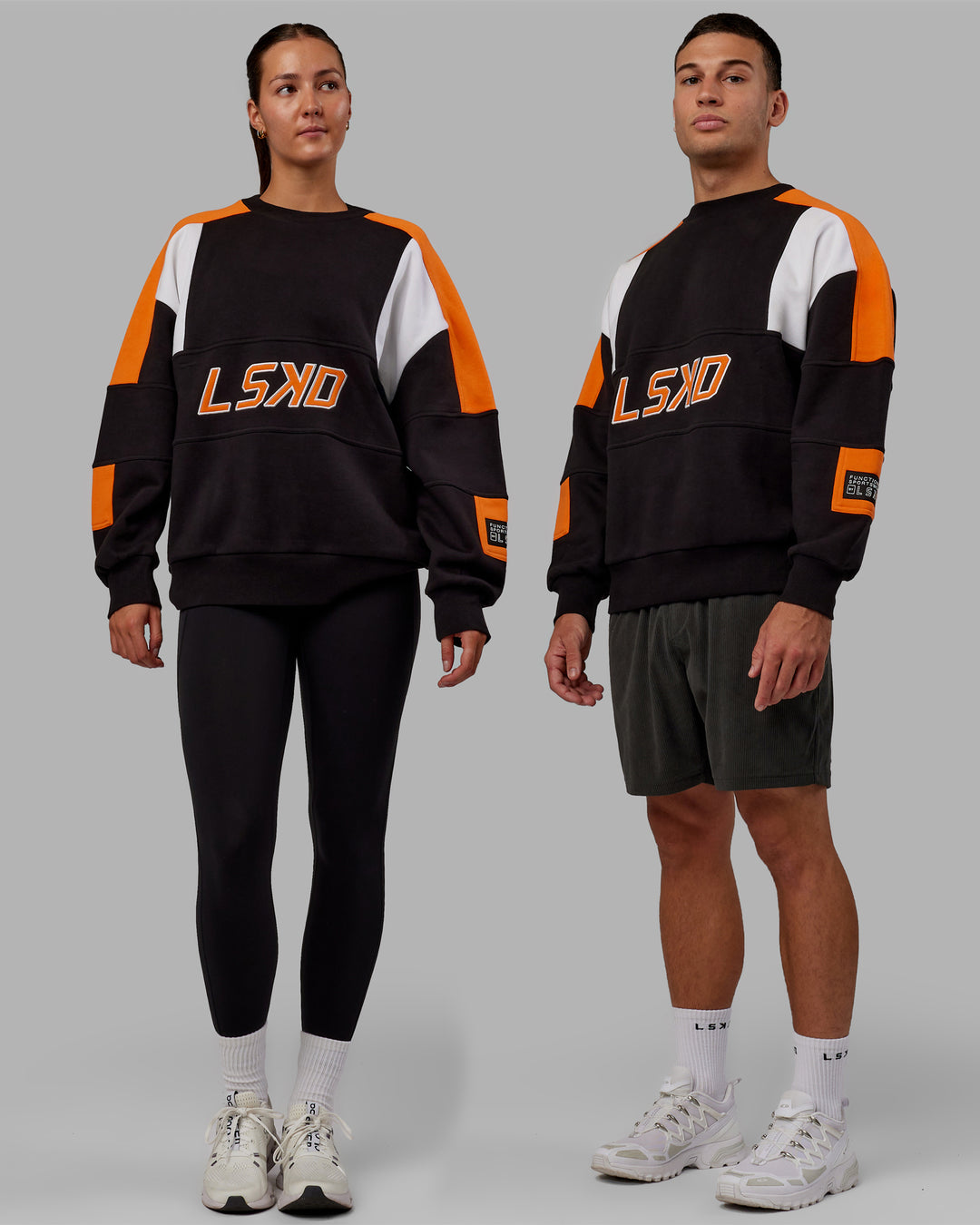 Duo wearing Unisex Slam Sweater Oversize - Black-Ultra Orange