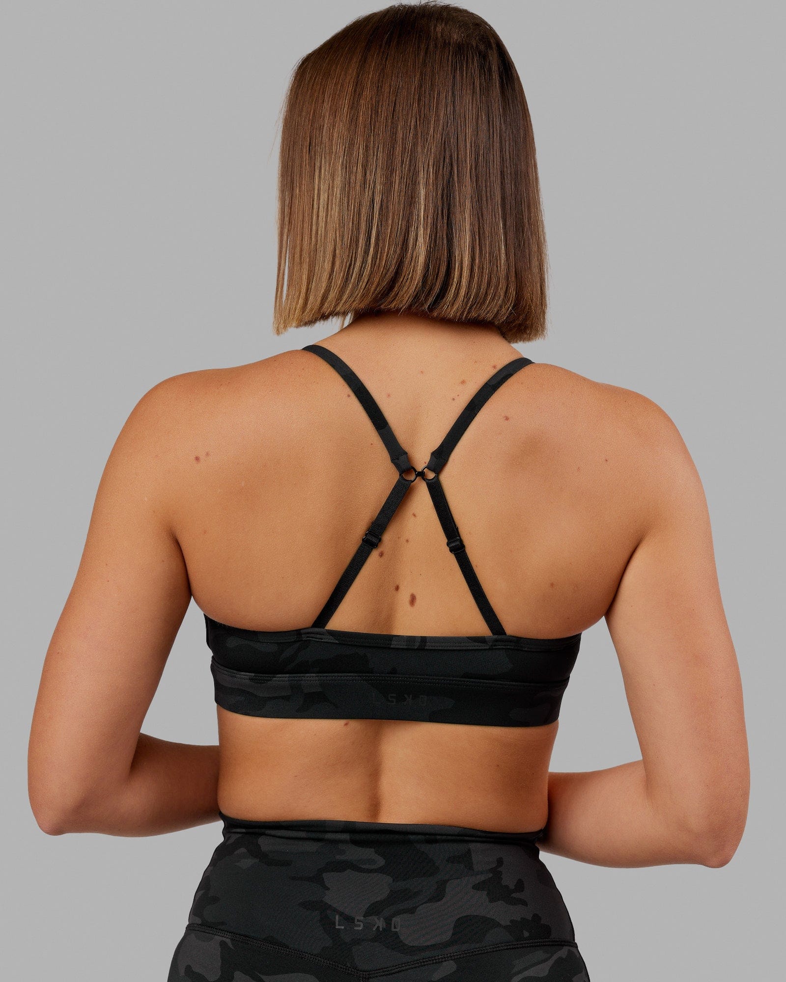 Woman wearing Elixir Sports Bra - Black Camo