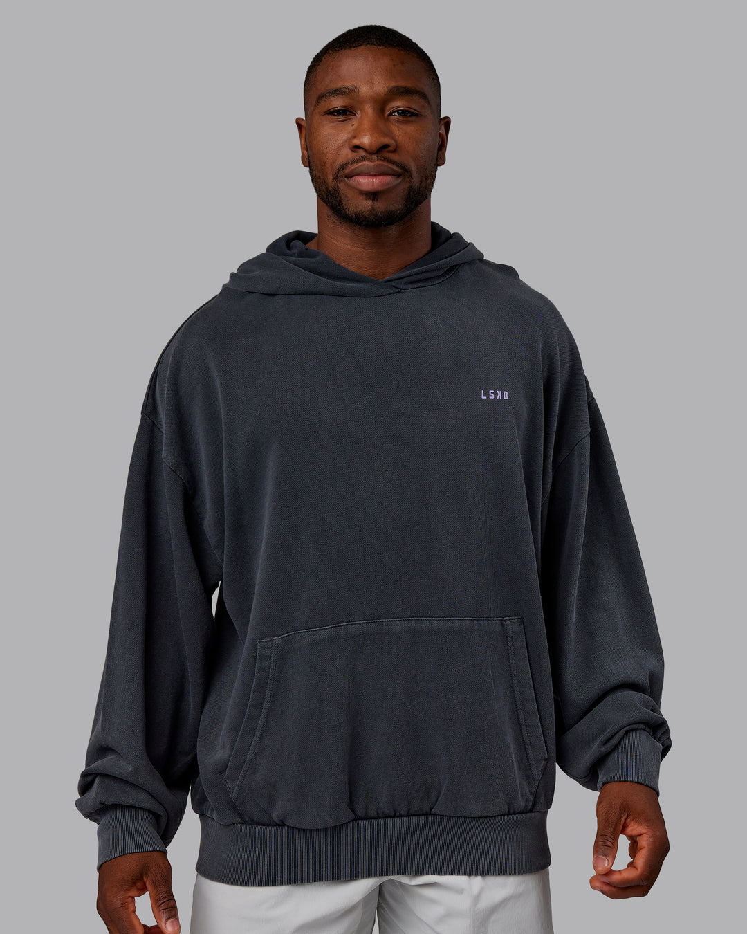 Man wearing 1% Better Value Series Oversized Hoodie - Black-Violet Ray | Model:Sam | Size:L