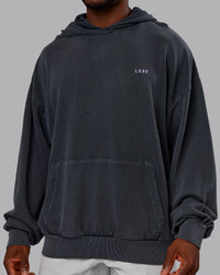 Man wearing 1% Better Value Series Oversized Hoodie - Black-Violet Ray | Model:Sam | Size:L