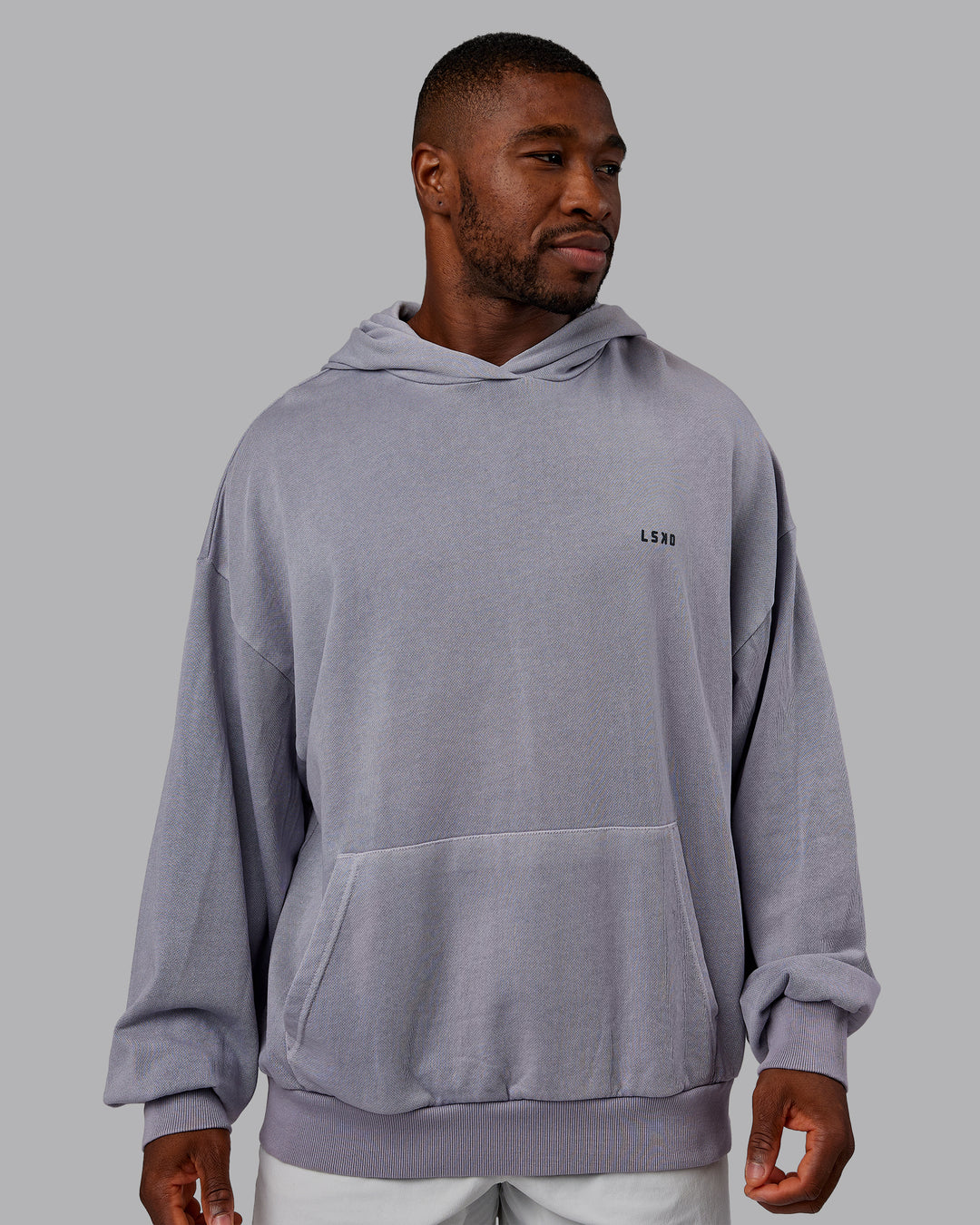 Man wearing 1% Better Value Series Oversized Hoodie - Violet Ray-Black | Model:Sam | Size:L