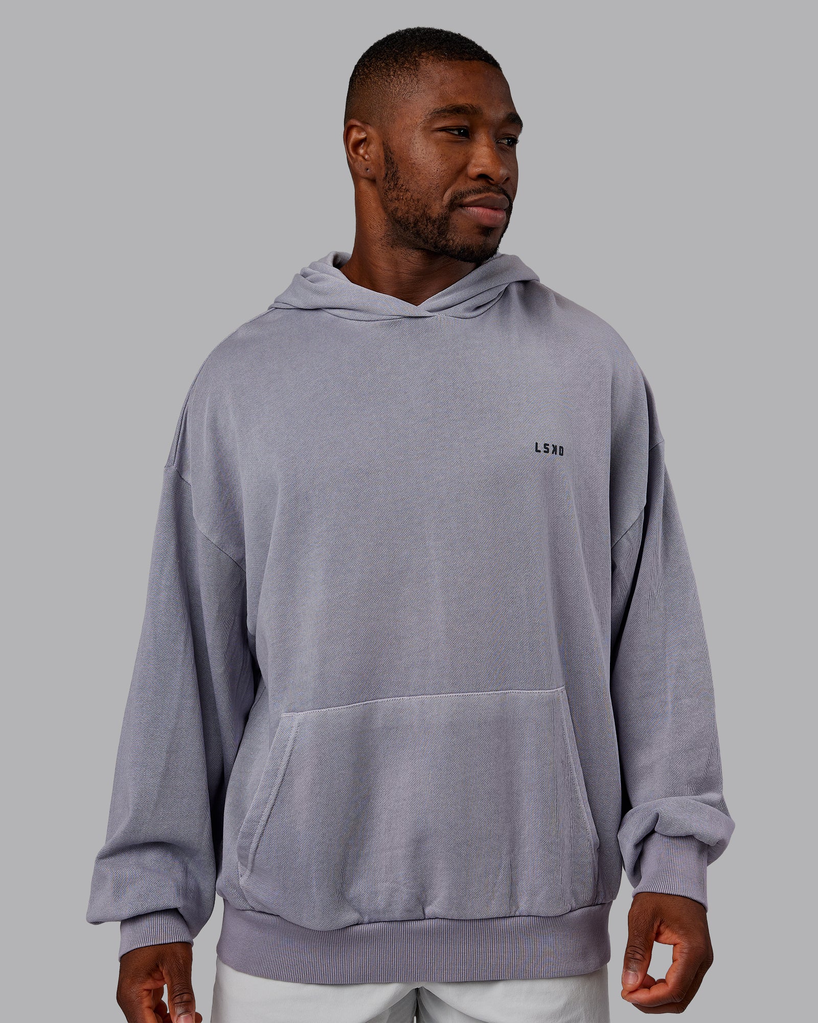 Man wearing 1% Better Value Series Oversized Hoodie - Violet Ray-Black | Model:Sam | Size:L