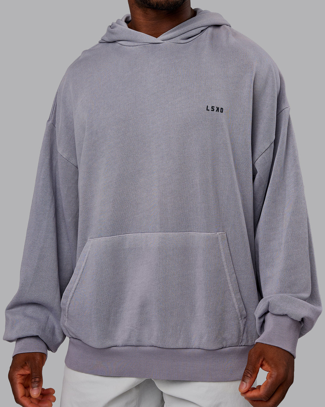 Man wearing 1% Better Value Series Oversized Hoodie - Violet Ray-Black | Model:Sam | Size:L