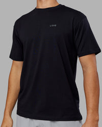 Man wearing 1% Better Value Series FLXCotton Tee Oversize - Black-Black | Model:Jackson | Size:L