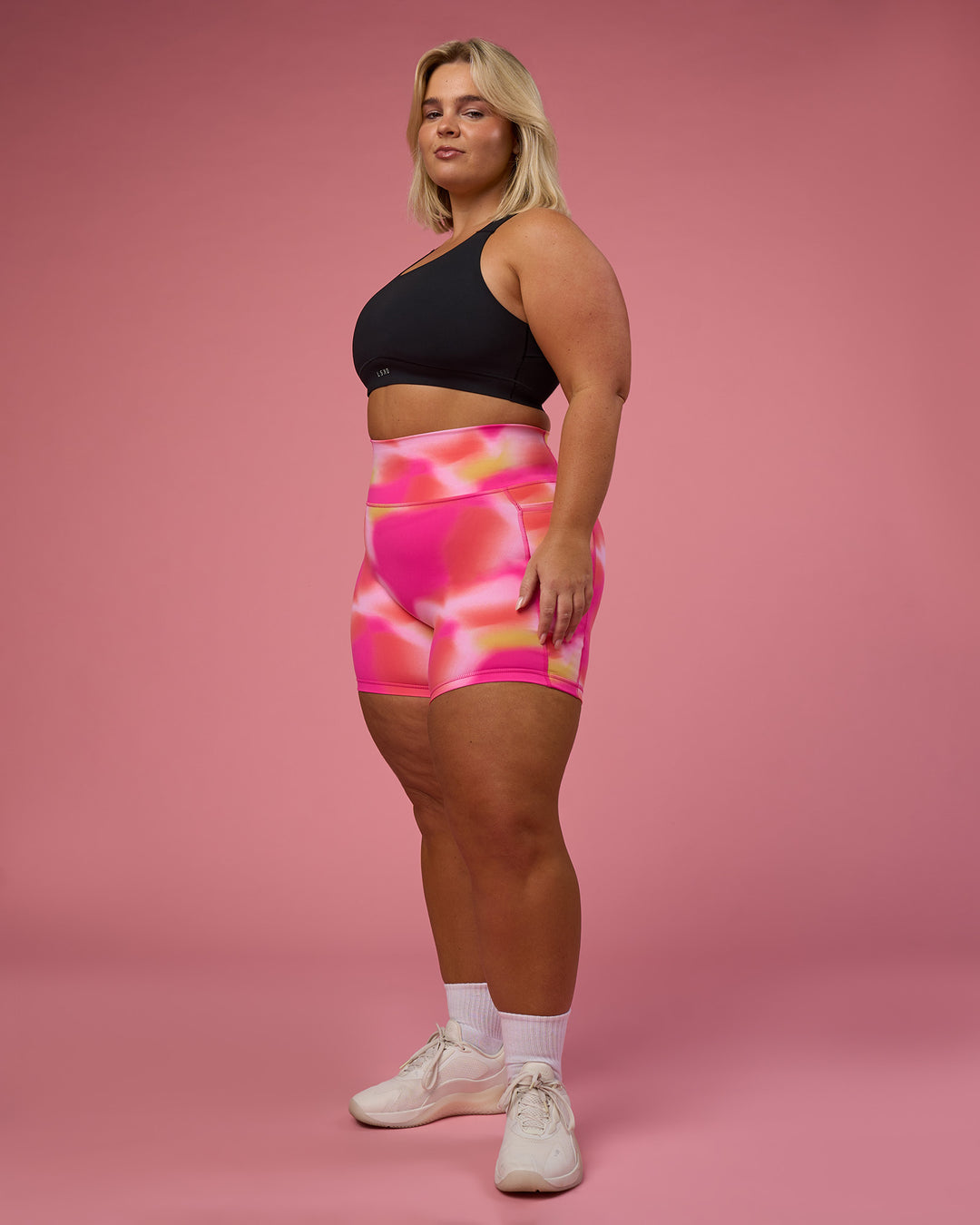 Woman wearing Fusion Ultra High-Rise 6&quot; Short Pockets - Pink Glow Print | Model:Bianca | Size:L