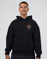 Man wearing GTC CVC Fleece Unisex Oversized Hoodie - Black-Cantaloupe | Model:Nikola | Size:L