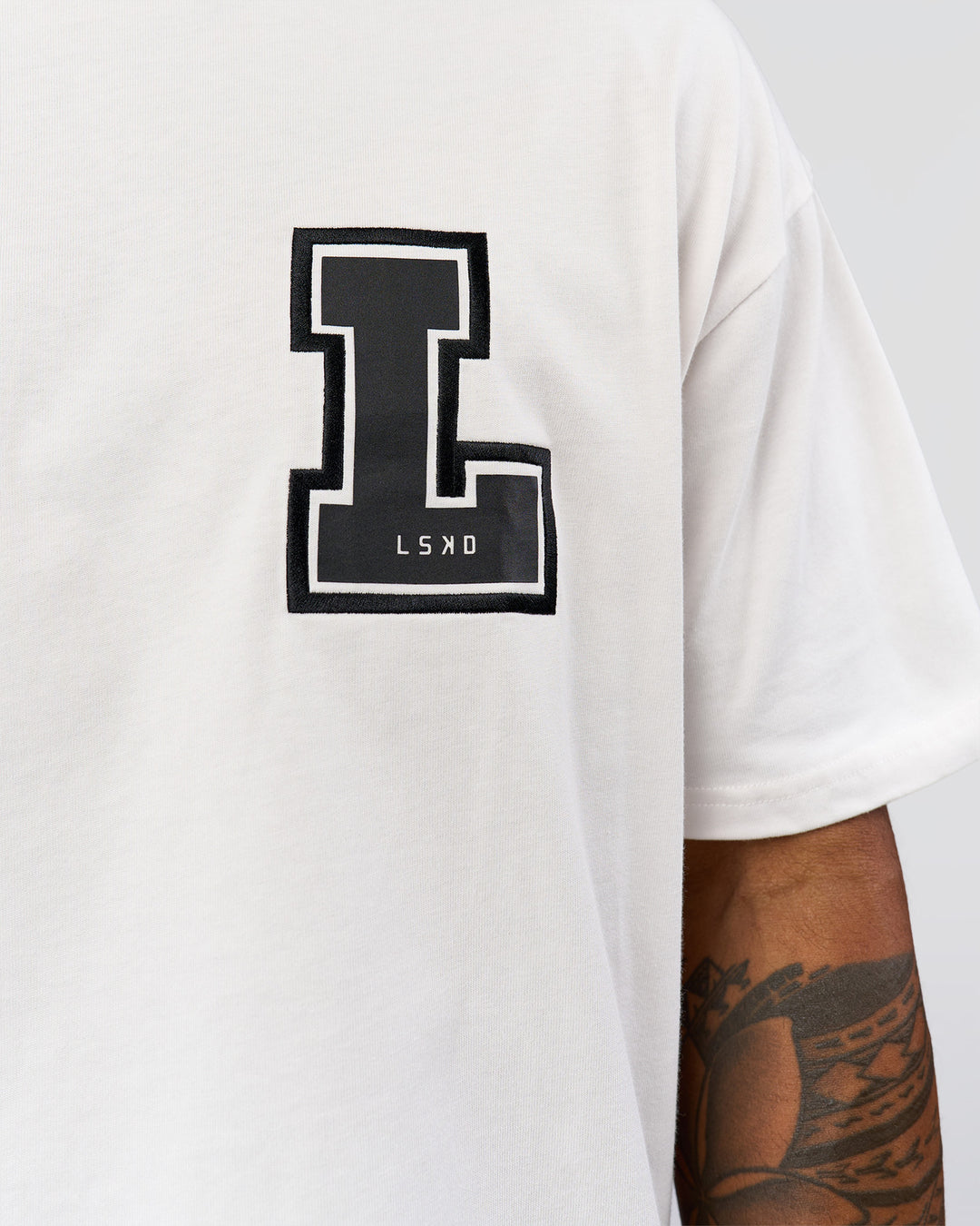 Man wearing Hype Heavyweight Unisex Oversized Tee - Off White-Black | Model:Xavier | Size:L