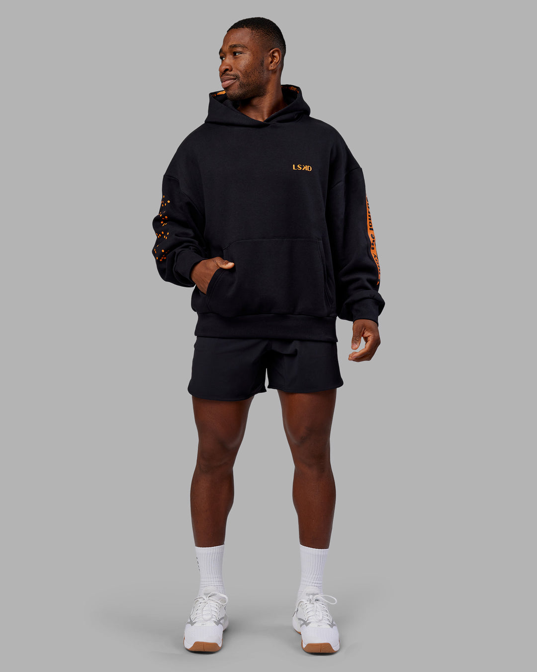 Man wearing Hyped Unisex Oversized Hoodie - Black-Vibrant Orange | Model:Sam | Size:L