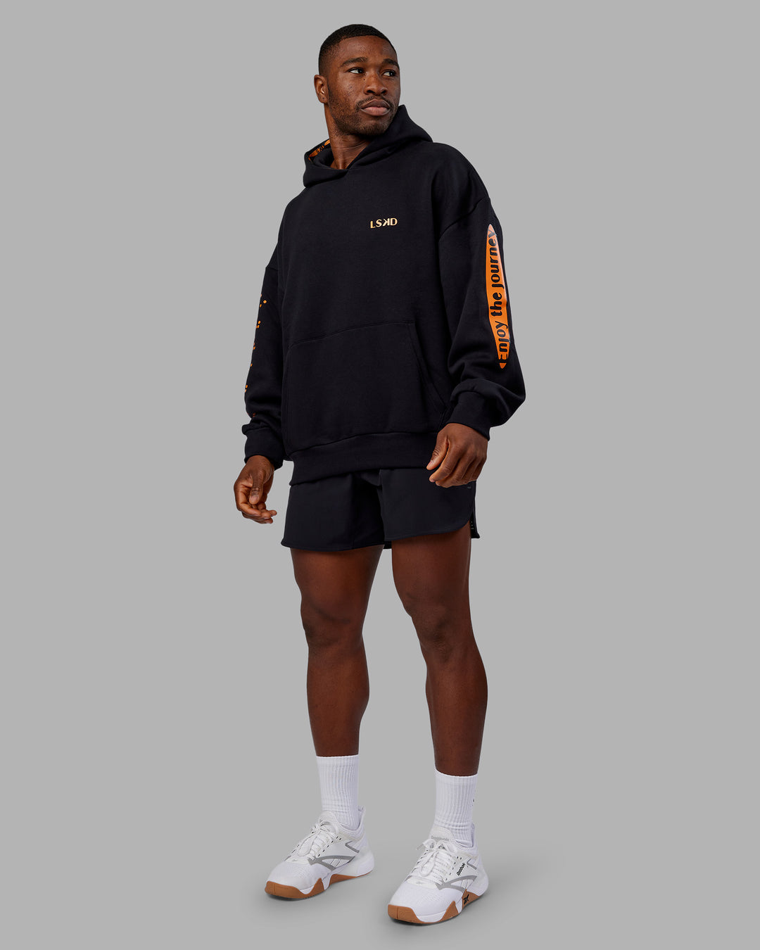 Man wearing Hyped Unisex Oversized Hoodie - Black-Vibrant Orange | Model:Sam | Size:L