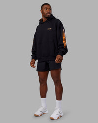Man wearing Hyped Unisex Oversized Hoodie - Black-Vibrant Orange | Model:Sam | Size:L