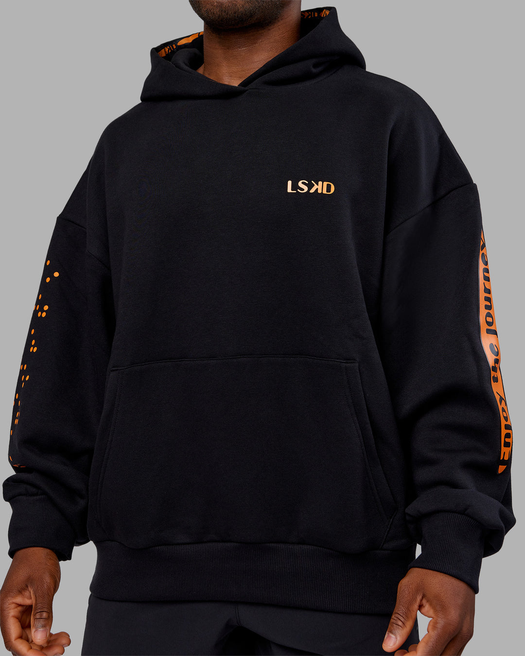Man wearing Hyped Unisex Oversized Hoodie - Black-Vibrant Orange | Model:Sam | Size:L