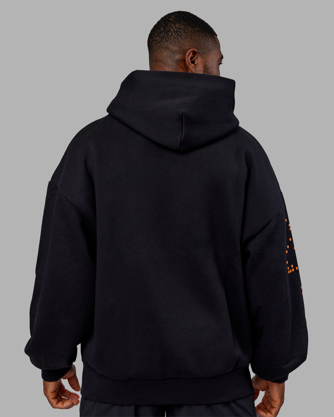 Man wearing Hyped Unisex Oversized Hoodie - Black-Vibrant Orange | Model:Sam | Size:L