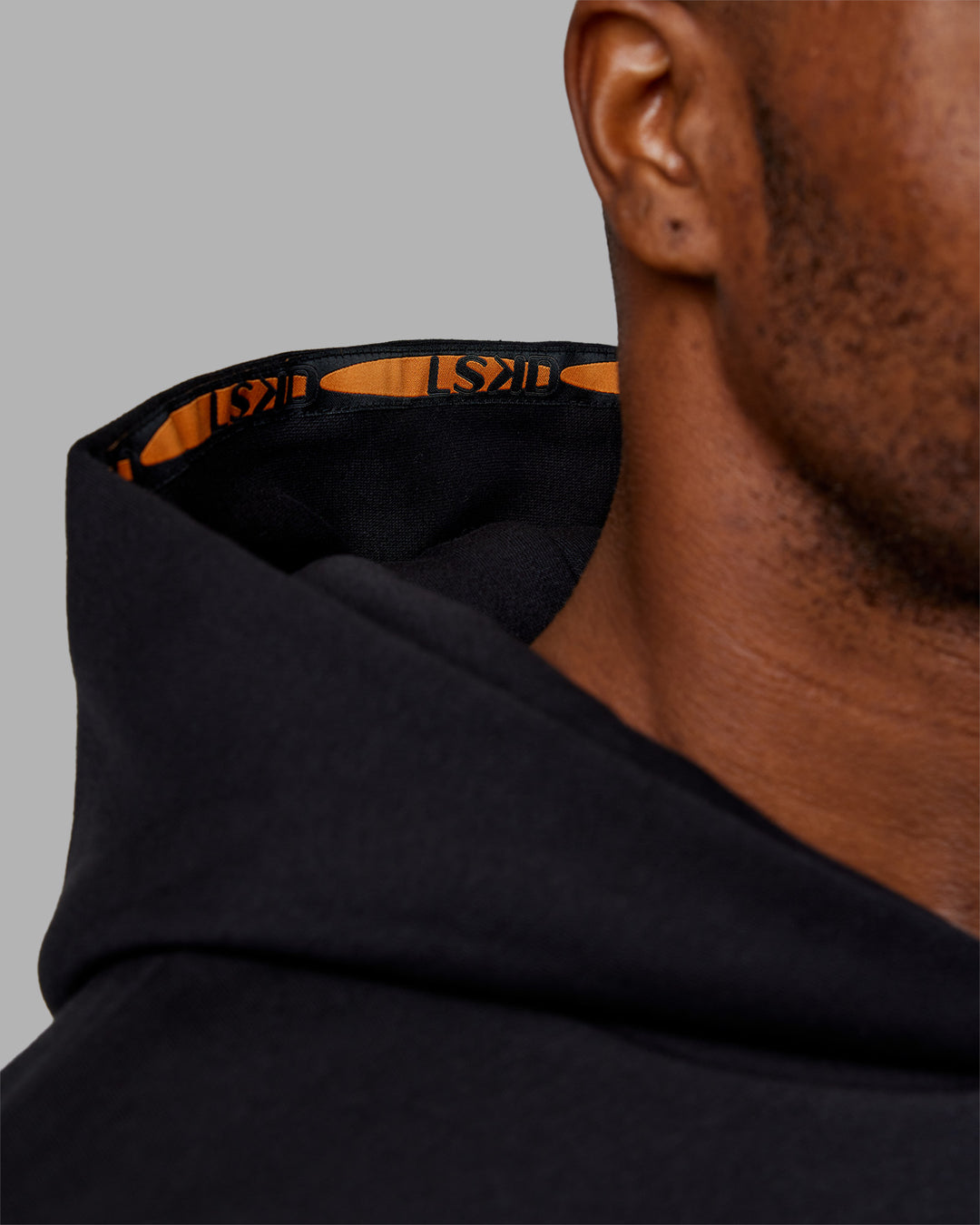 Man wearing Hyped Unisex Oversized Hoodie - Black-Vibrant Orange | Model:Sam | Size:L