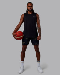 Man wearing Patty Mills Challenger 6" Performance Shorts - Black-Vital Green