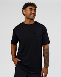 Man wearing RUN CLUB FLXCotton Tee Oversize - Black-Scarlet | Model:Xav | Size:L 