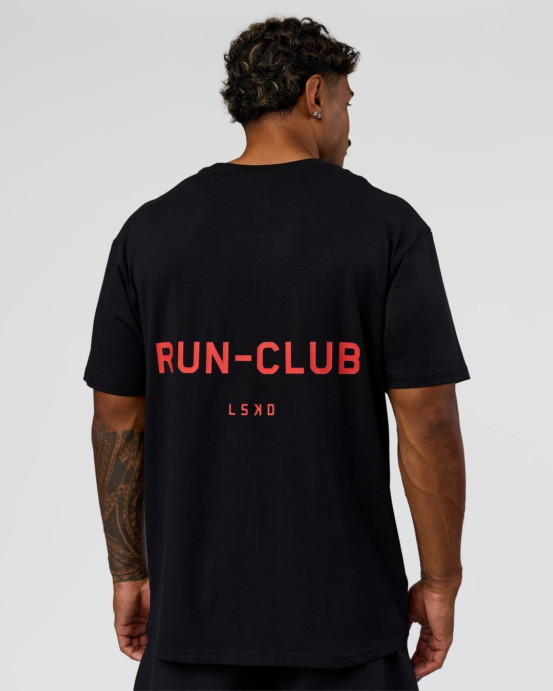 Man wearing RUN CLUB FLXCotton Tee Oversize - Black-Scarlet | Model:Xav | Size:L 