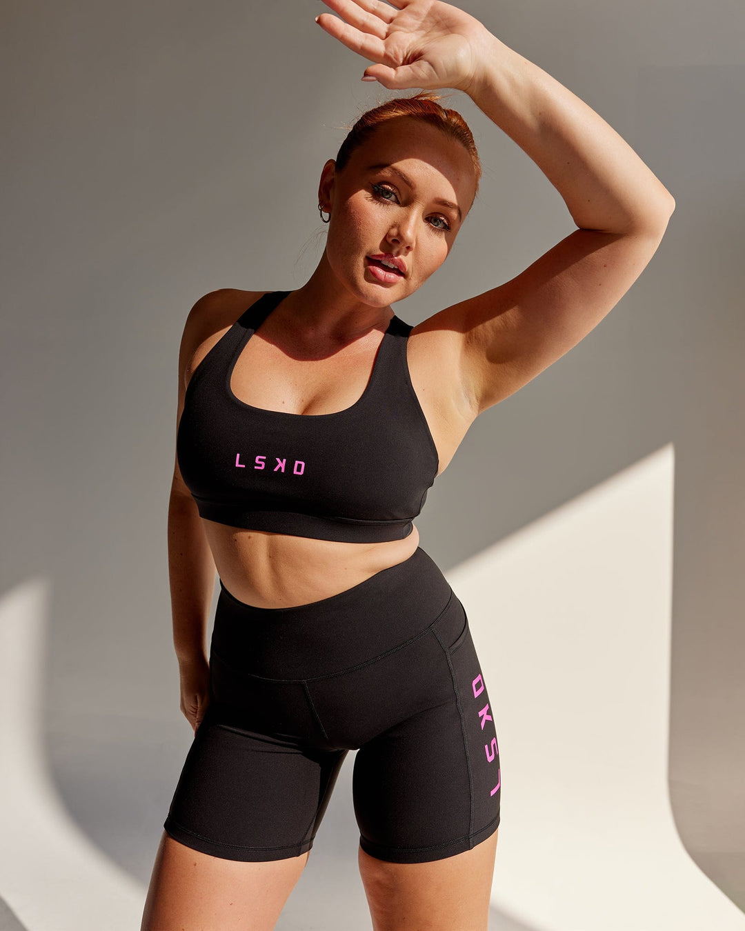 Woman wearing Rep Sports Bra Small Logo - Black-Neon Magenta