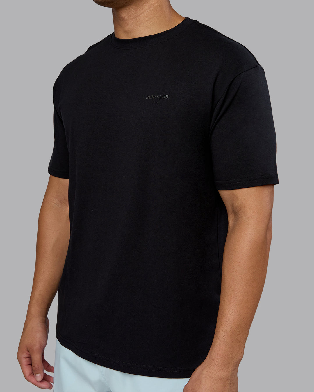 Man wearing RUN CLUB FLXCotton Tee Oversize - Black-Reflective | Model:Kaelyb | Size:L