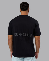 Man wearing RUN CLUB FLXCotton Tee Oversize - Black-Reflective | Model:Kaelyb | Size:L