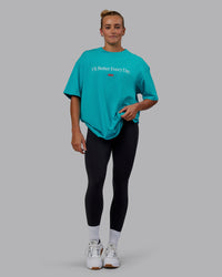 Woman wearing Unisex 1% Better FLXCotton Tee Oversize - Blue Bird-White