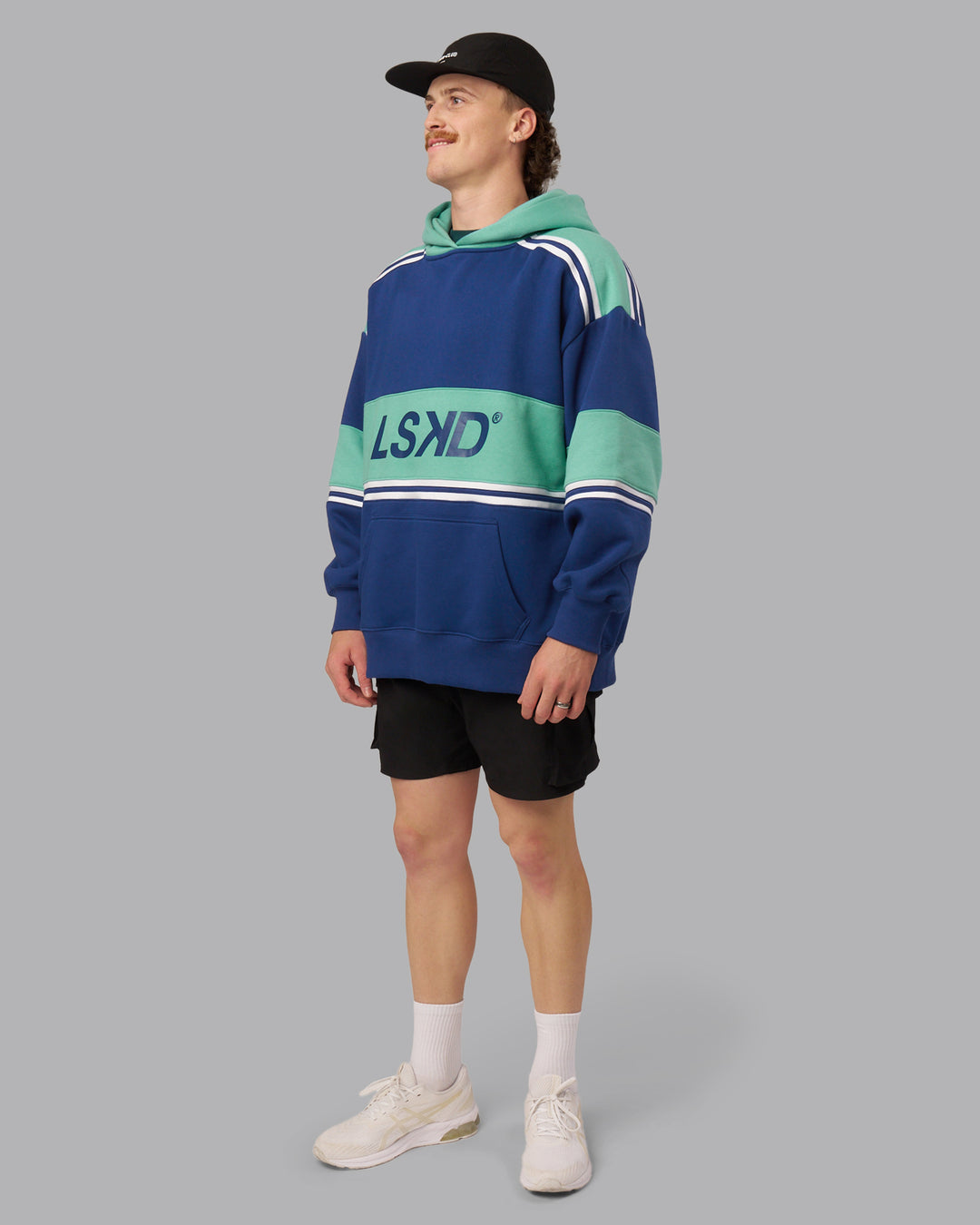 Man wearing A-Team Oversized Hoodie - Midnight Blue-Agate Green | Model:Isaac| Size:L