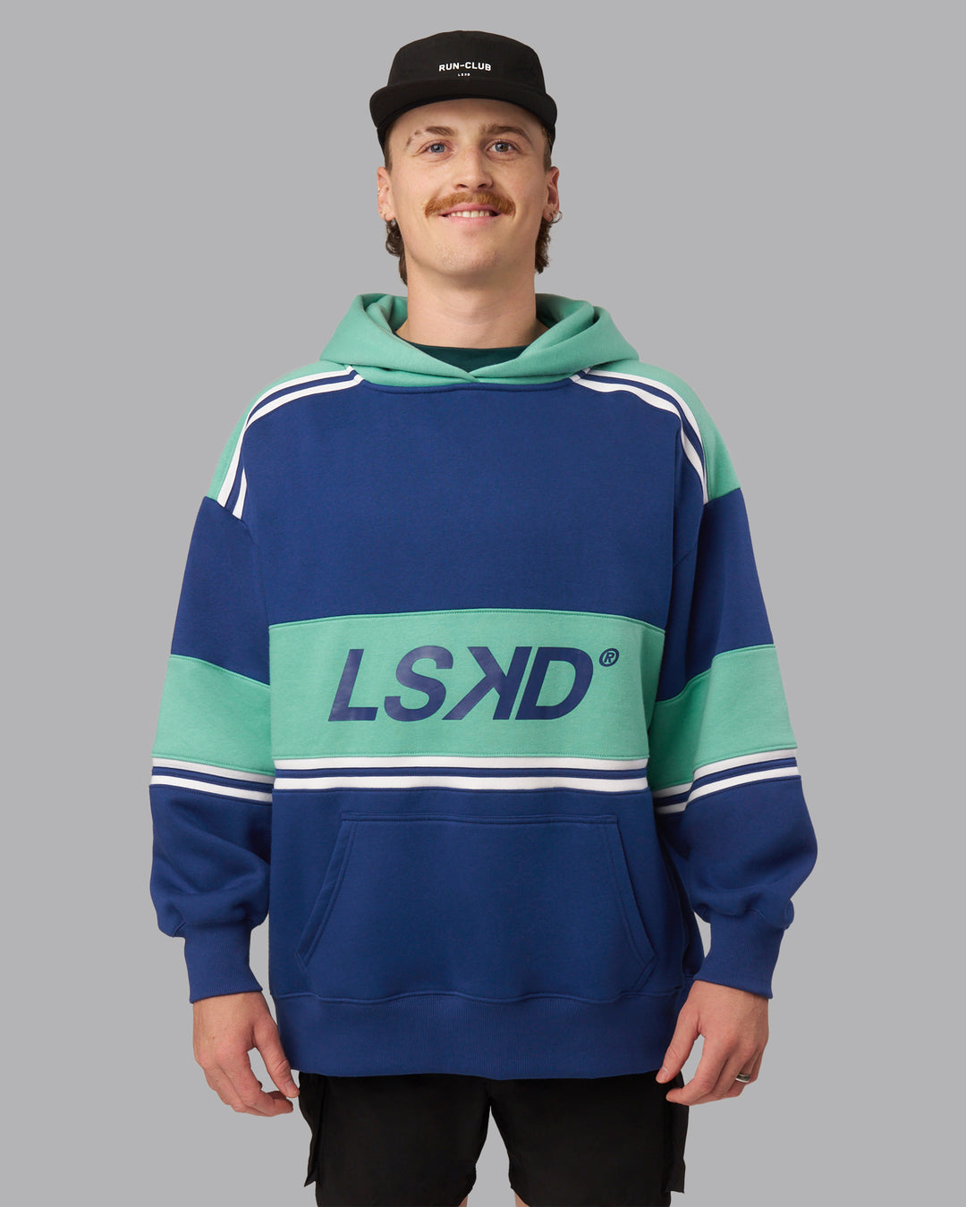Man wearing A-Team Oversized Hoodie - Midnight Blue-Agate Green | Model:Isaac| Size:L