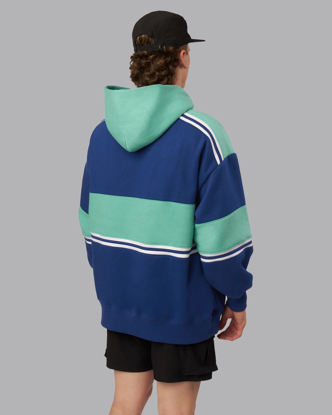 Man wearing A-Team Oversized Hoodie - Midnight Blue-Agate Green | Model:Isaac| Size:L