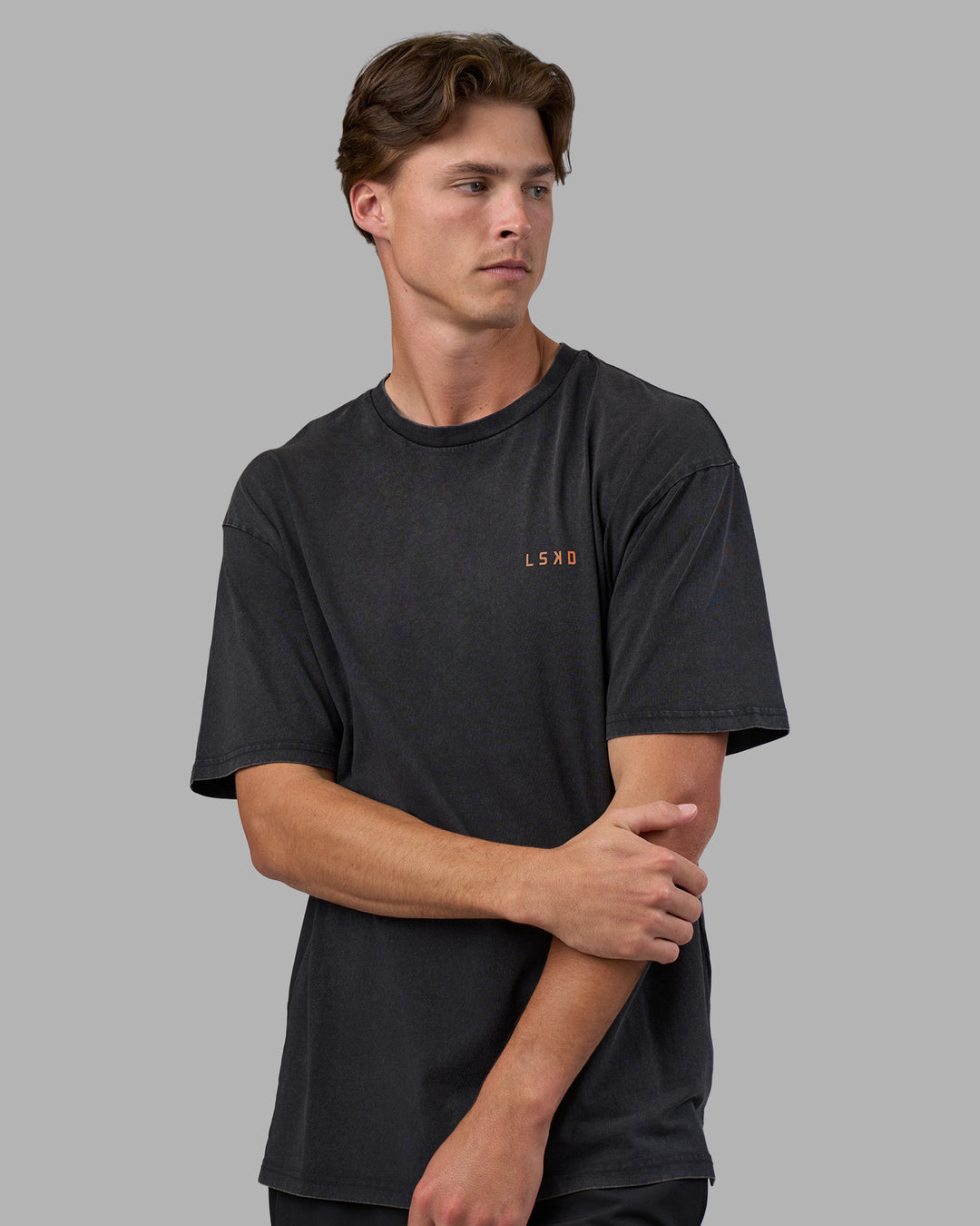 Man wearing Unisex Strike Through FLXCotton Tee Oversize - Black Washed-Cantaloupe | Model:Brandon | Size:L