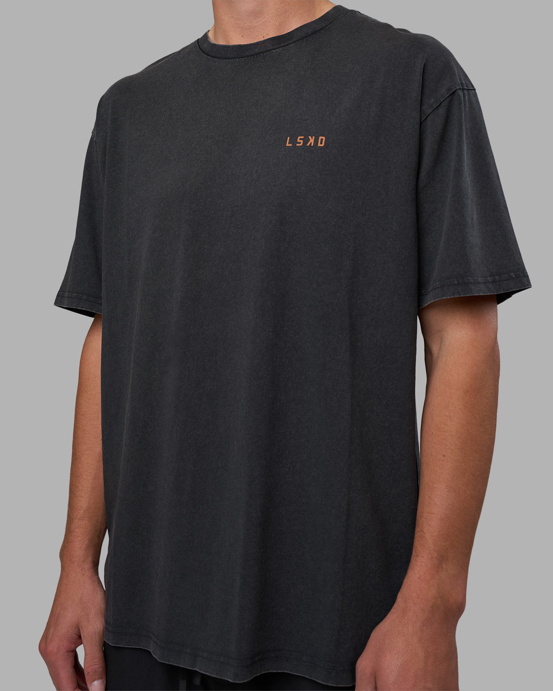 Man wearing Unisex Strike Through FLXCotton Tee Oversize - Black Washed-Cantaloupe | Model:Brandon | Size:L