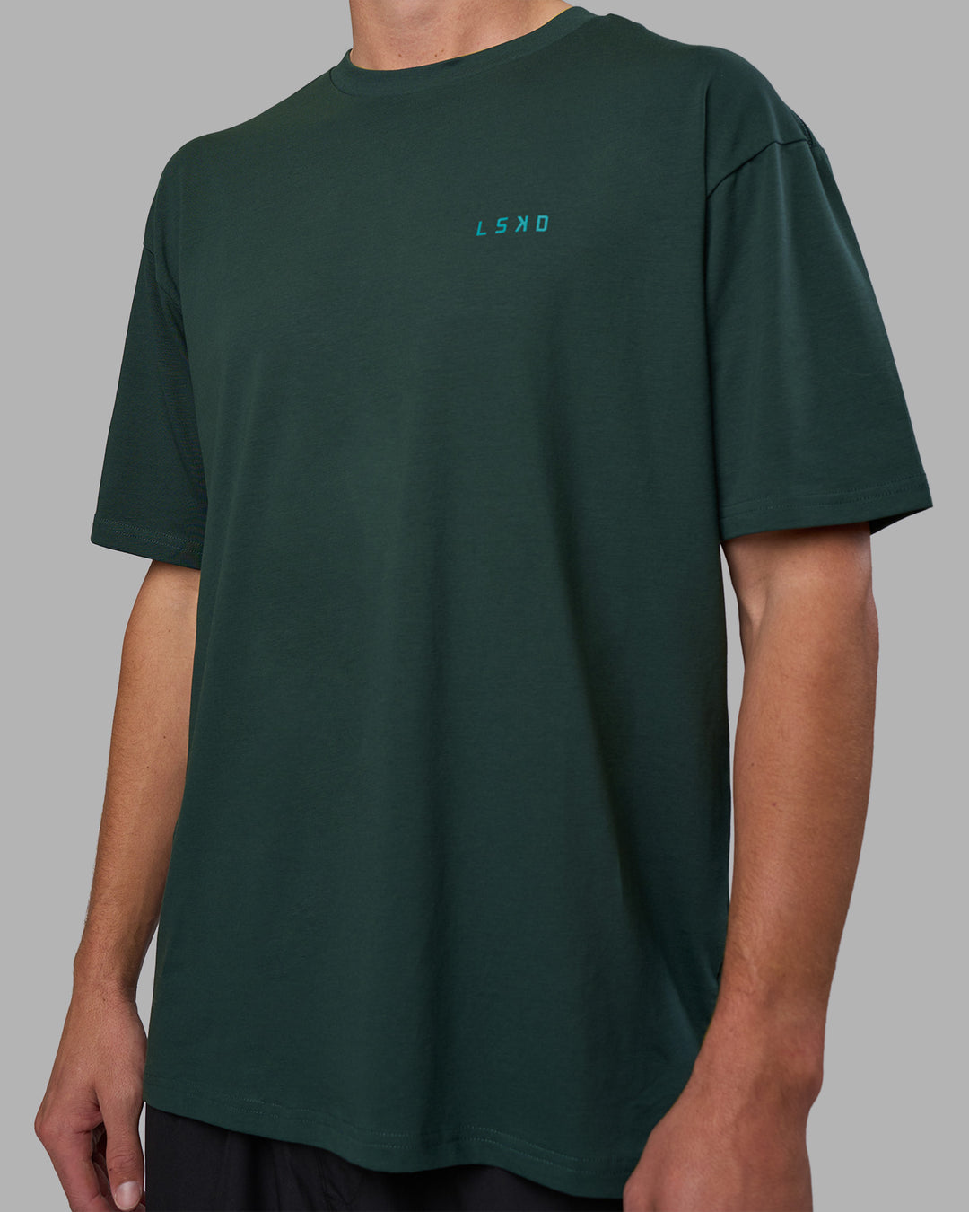 Man wearing Unisex Strike Through FLXCotton Tee Oversize - Vital Green-Alexandrite | Model:Brandon | Size:L