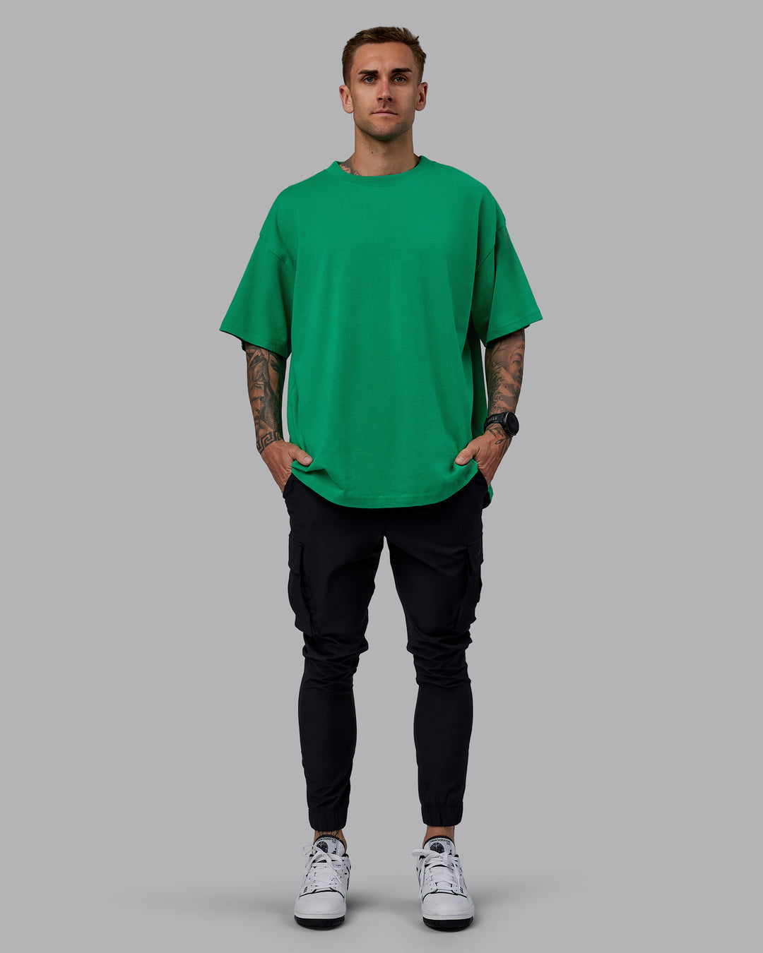 Man wearing Unisex We Rise Heavyweight Tee Oversize - Impact Green-White