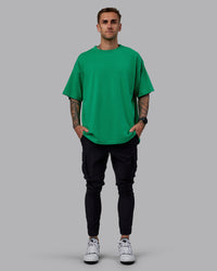 Man wearing Unisex We Rise Heavyweight Tee Oversize - Impact Green-White