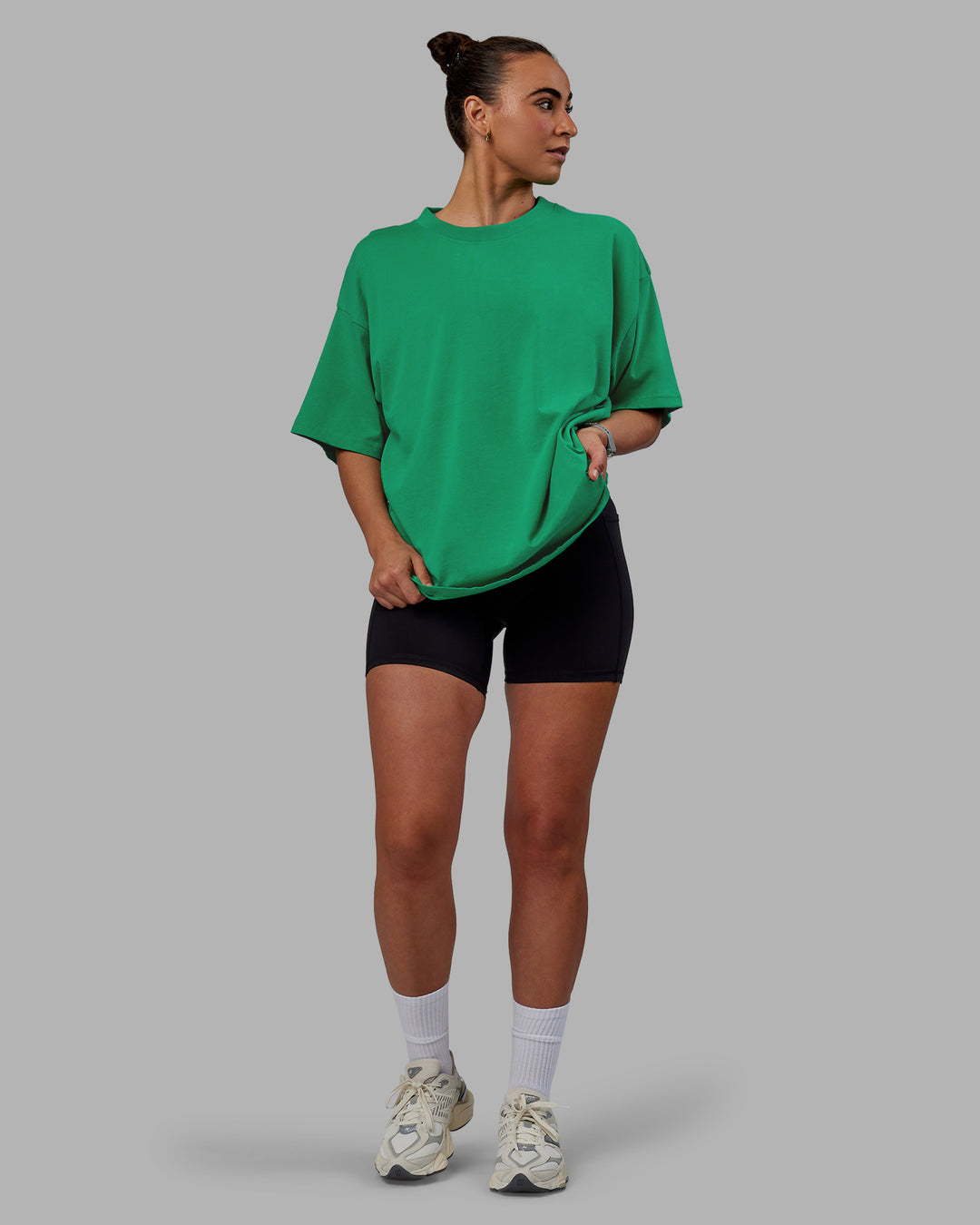 Woman wearing Unisex We Rise Heavyweight Tee Oversize - Impact Green-White