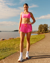Woman wearing Accelerate 3" Pleated Running Short - Ultra Pink | Model:Phoebe | Size:M