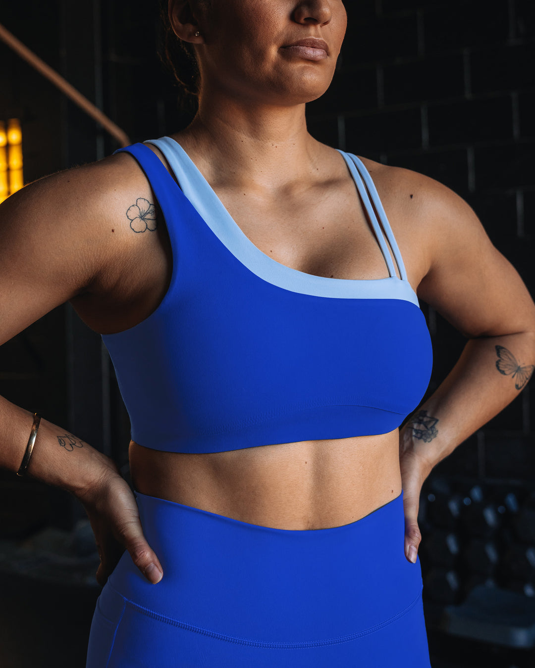 Woman wearing Thrive Asymmetric Sports Bra - Power Cobalt-Open Air | Model:Tiare | Size:M