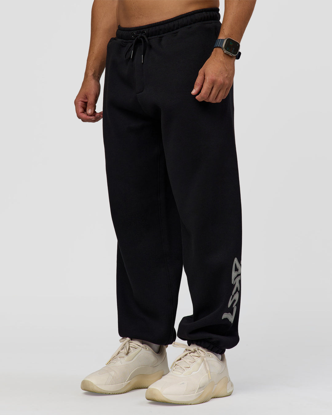 Man wearing Static Grit Baggy Track Pant - Black-Alloy | Model:Jaiden | Size:M