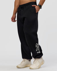 Man wearing Static Grit Baggy Track Pant - Black-Alloy | Model:Jaiden | Size:M