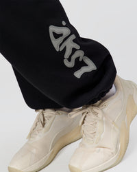 Man wearing Static Grit Baggy Track Pant - Black-Alloy | Model:Jaiden | Size:M