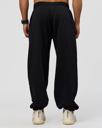 Man wearing Static Grit Baggy Track Pant - Black-Alloy | Model:Jaiden | Size:M