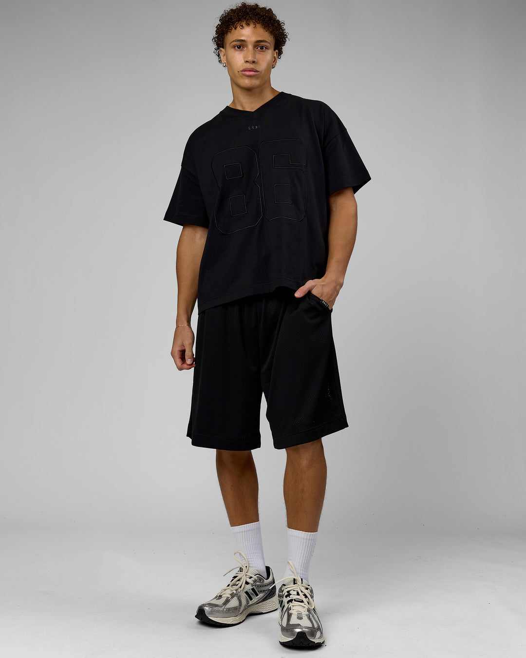 Man wearing 86 V-Neck Oversized Tee - Black-Black | Model:Leandro | Size:M