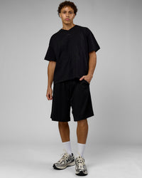 Man wearing 86 V-Neck Oversized Tee - Black-Black | Model:Leandro | Size:M